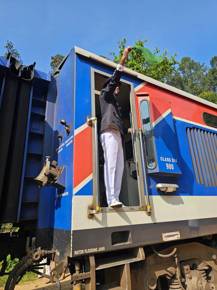 Personne debout sur les marches d'un train coloré.