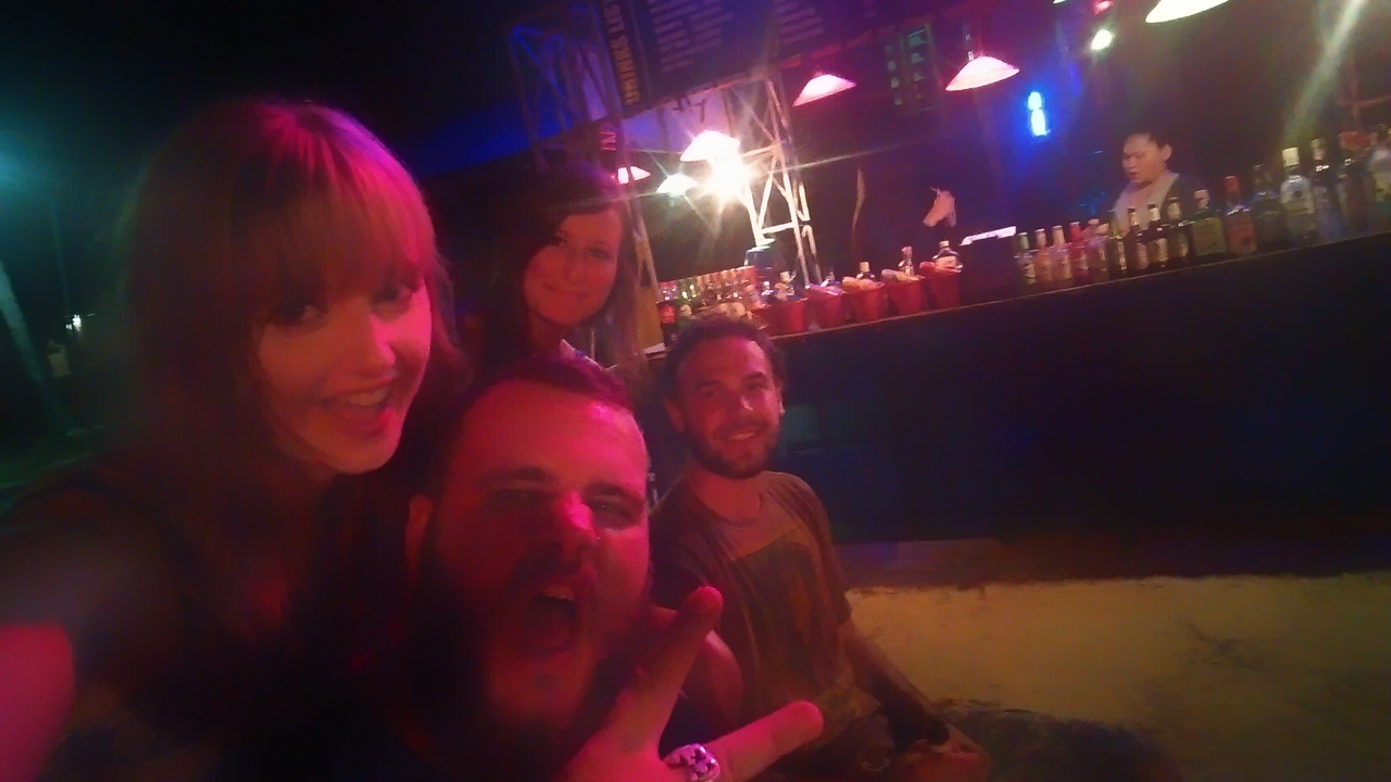 People having fun at a bar with dim lighting.