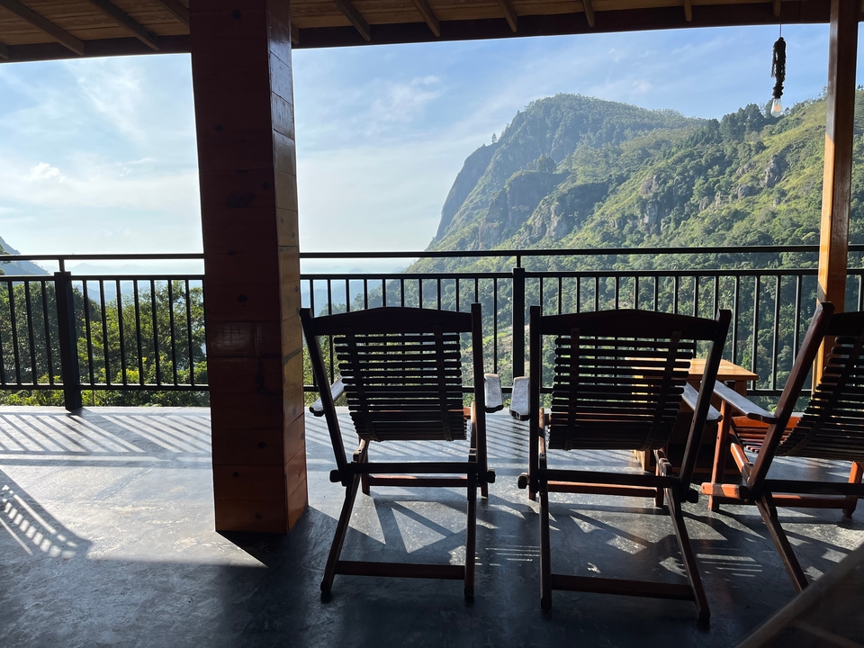Des chaises sur une terrasse avec une vue panoramique sur les montagnes.