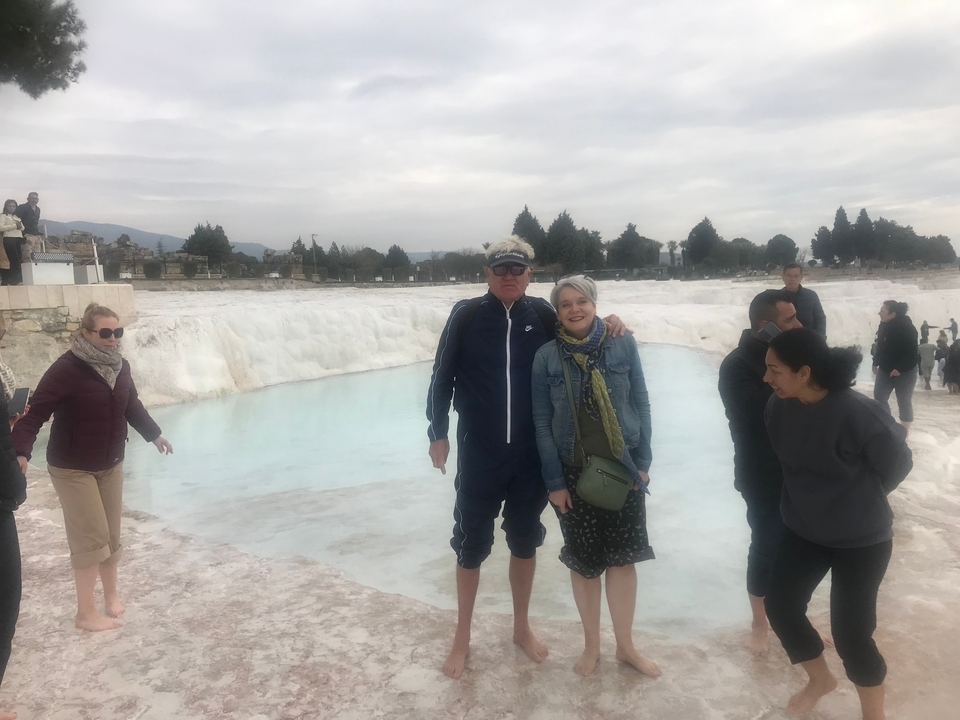 People standing at the edge of the thermal terraces in Pamukkale.