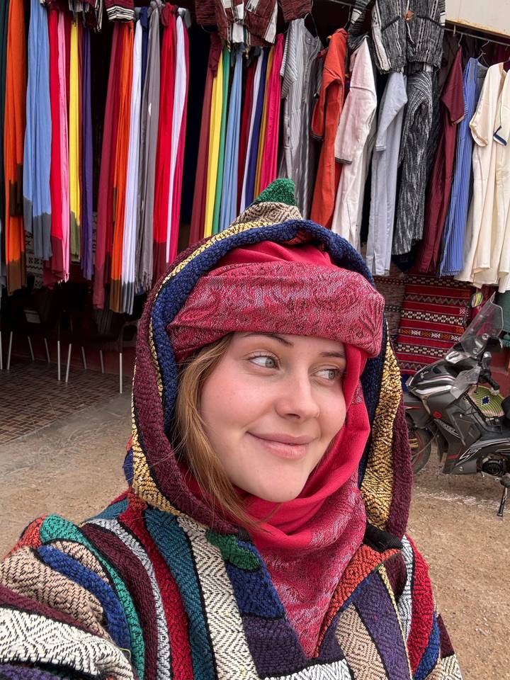 Person smiling, wearing colorful traditional clothing.