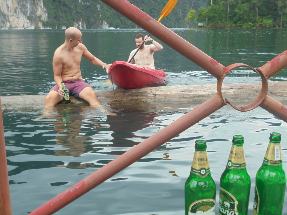 Two men enjoying kayaking with beers.