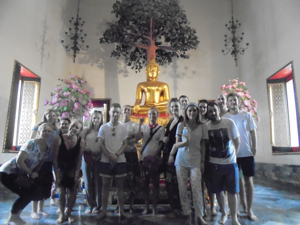 Group posing in front of a golden Buddha statue.