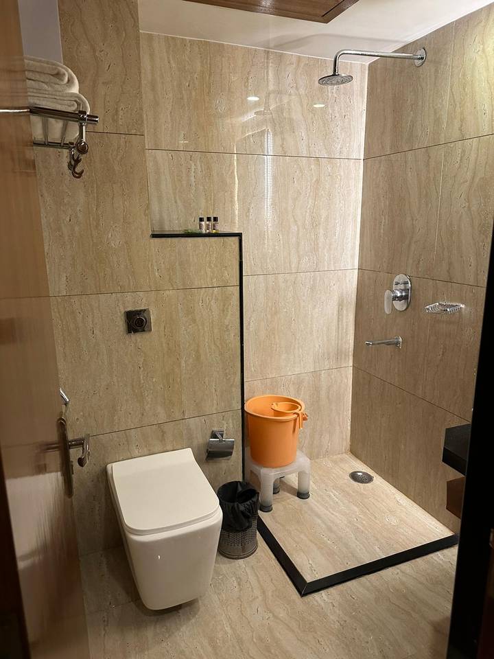 Badkamerinterieur met douche en emmer.