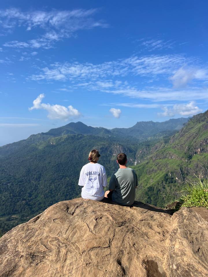 Deux personnes assises avec une vue panoramique sur les montagnes, probablement à Ella, au Sri Lanka.