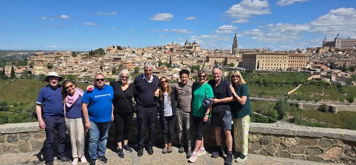 Large group of people posed with a scenic city view.