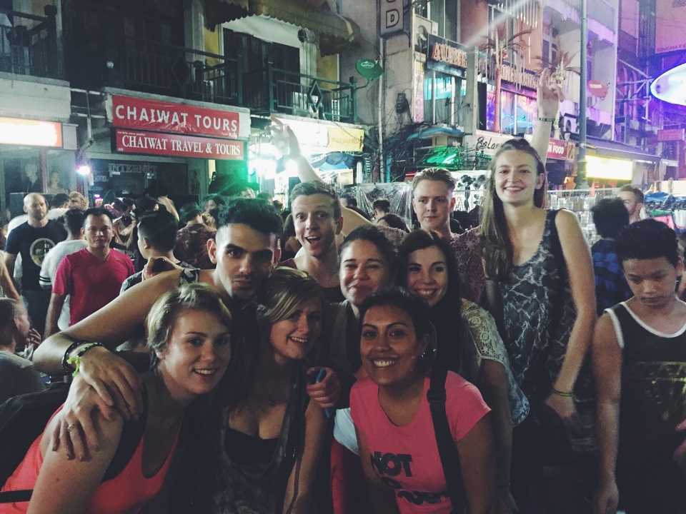 Group in a bustling city setting at night.