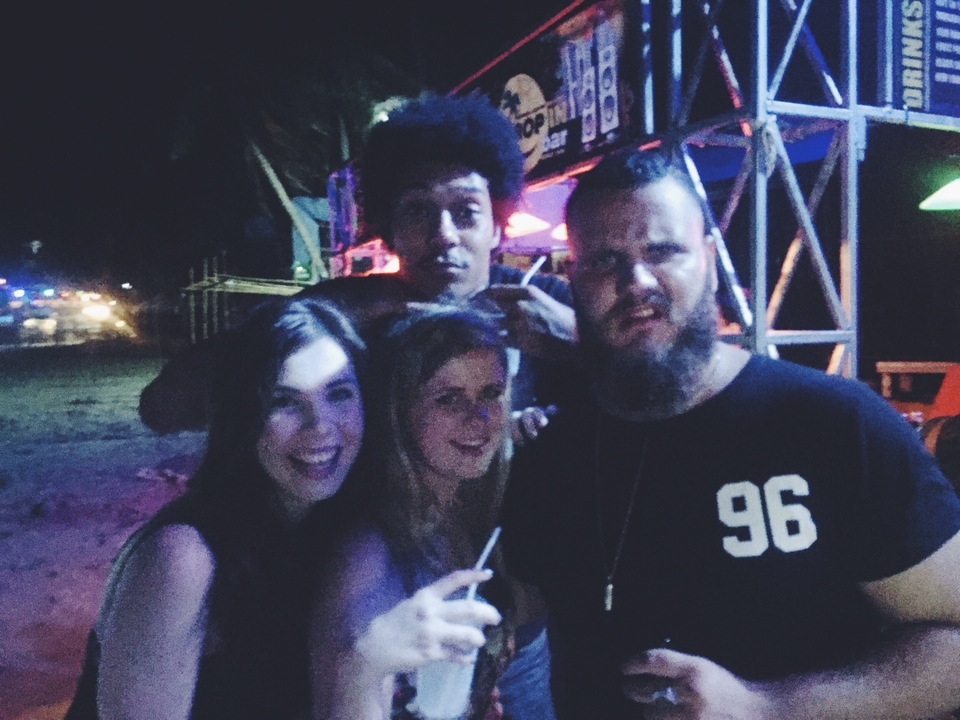 Group of friends at a dimly lit event at night.