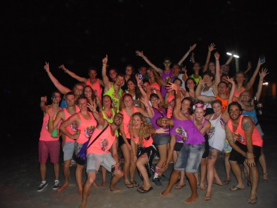 Large group of people at a nighttime beach party.
