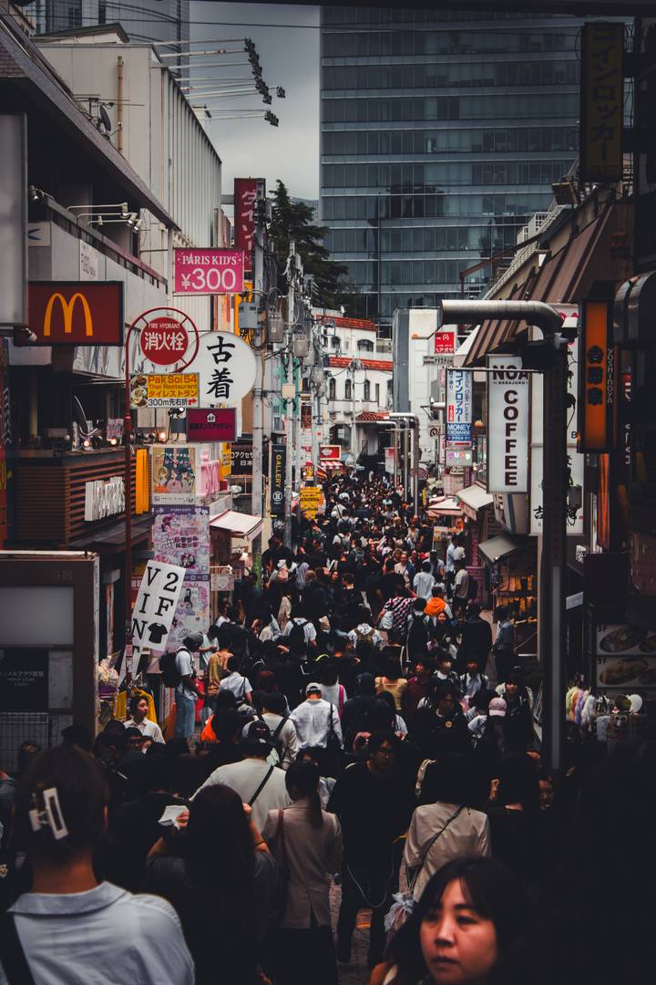 Crowded shopping street with signs in Japanese.