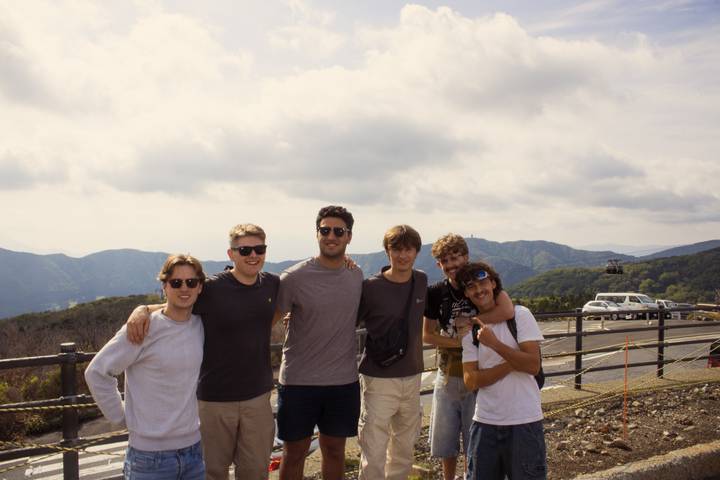 Group of friends posing with a scenic mountain view.