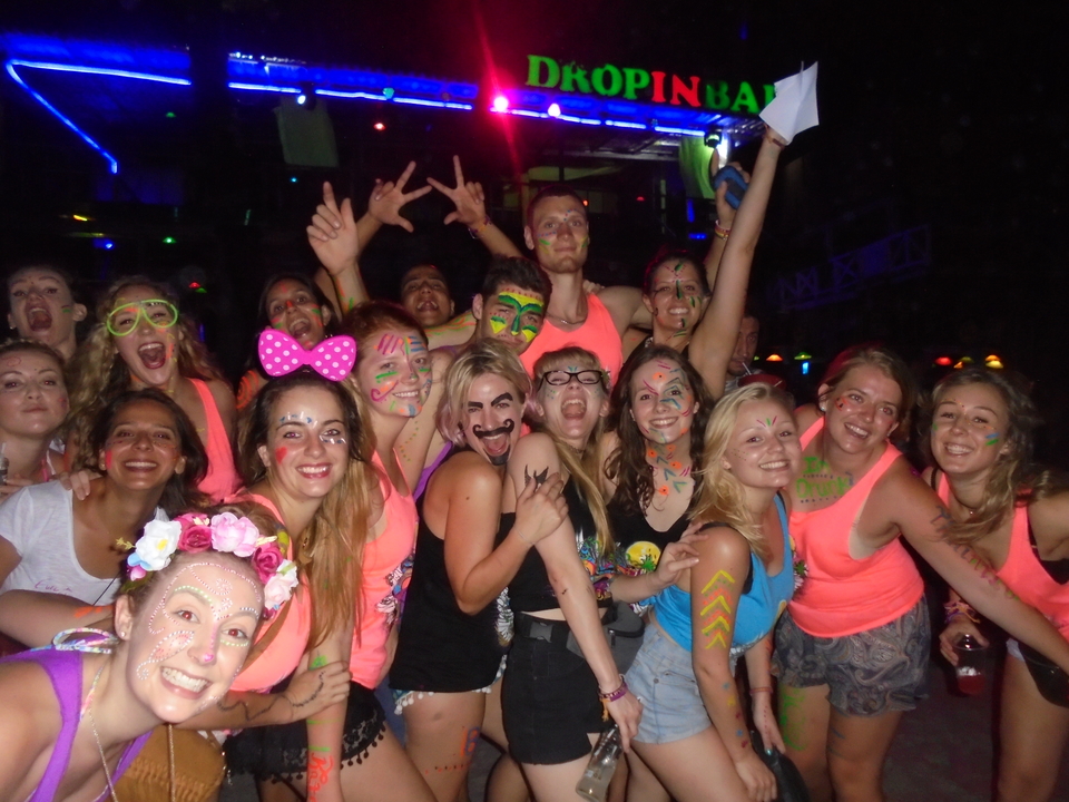 Group of people with neon body paint and glowing accessories.