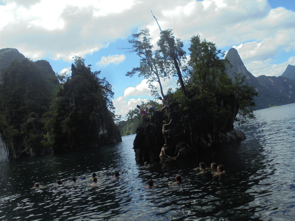 Lake surrounded by rocky mountains with swimmers around.
