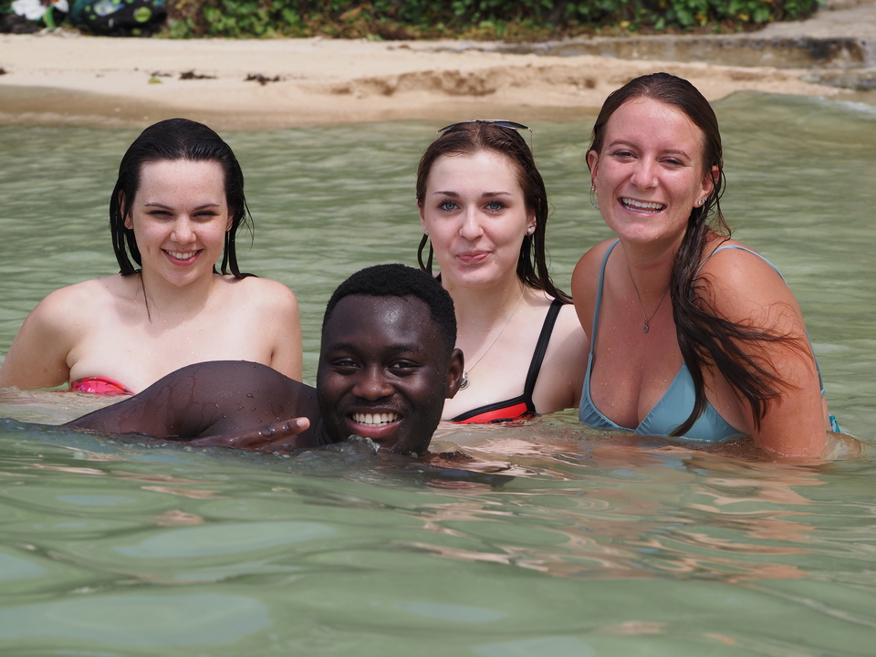 Group of people swimming and smiling in the water.