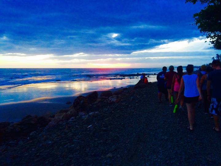 People walking along the coast during sunset.