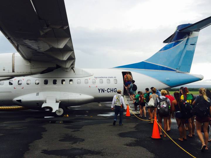 Group of people boarding a small aircraft.