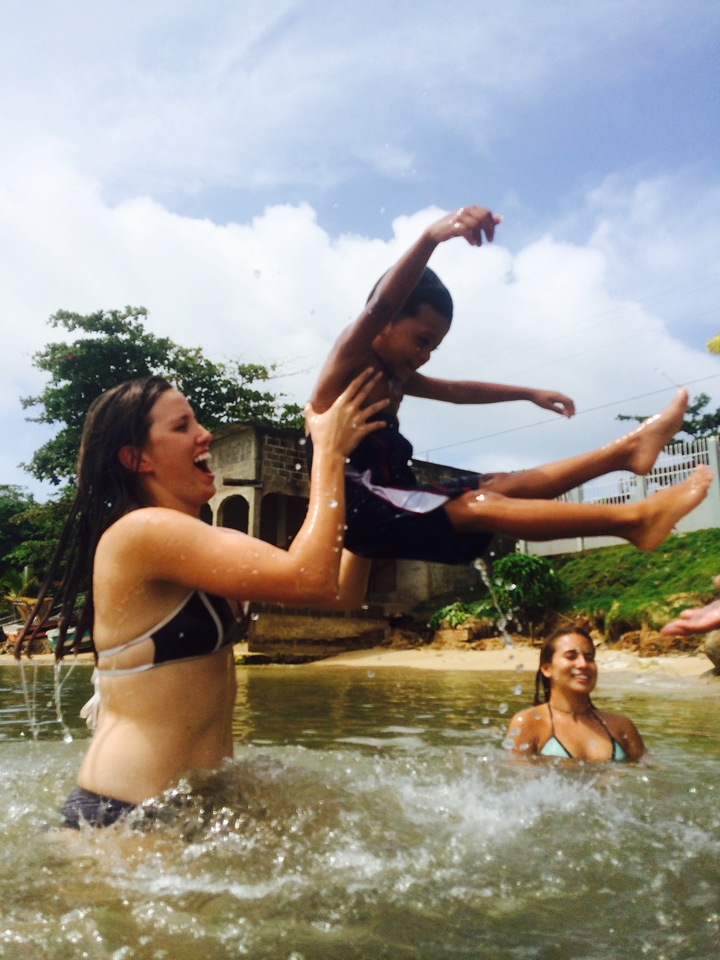 Person lifting a child joyfully in a beach setting.