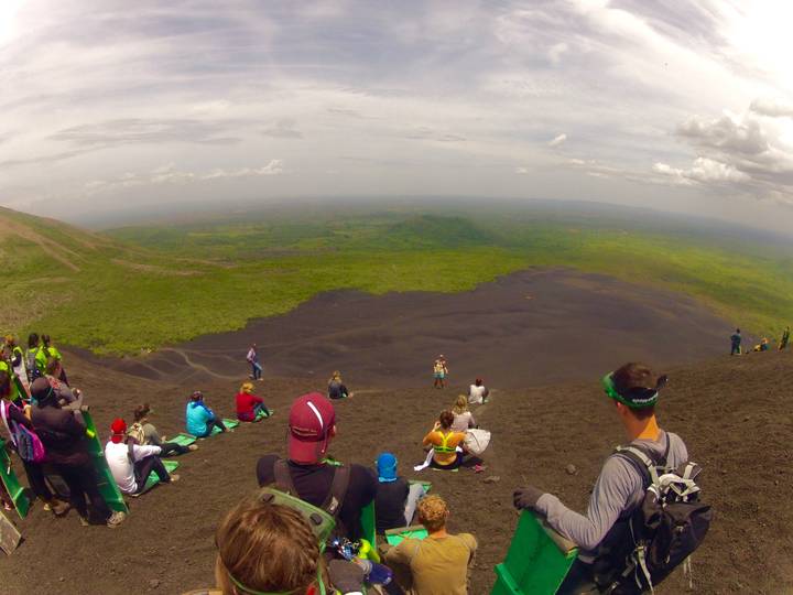Large group gathered on a slope overlooking a vast landscape.