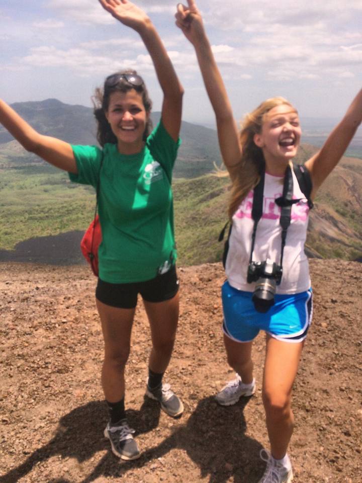 People celebrating on a hill with scenic views.