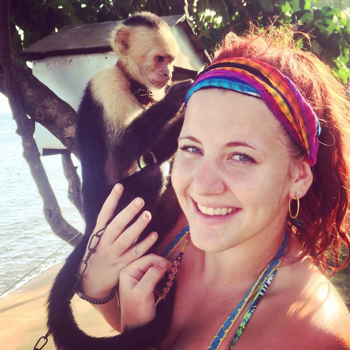 Person smiling with a monkey on their shoulder.
