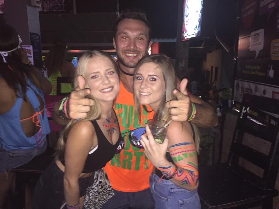 Three people posing and smiling at a party.