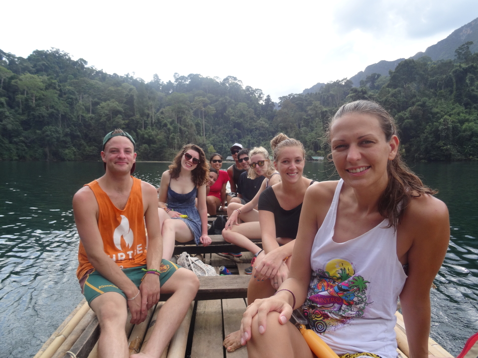 Group of people on a boat ride through a lake in a jungle.