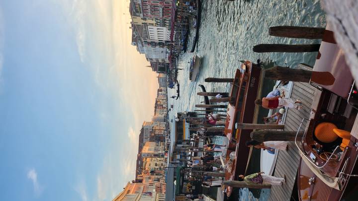 Crowded waterway with boats and people in Venice.