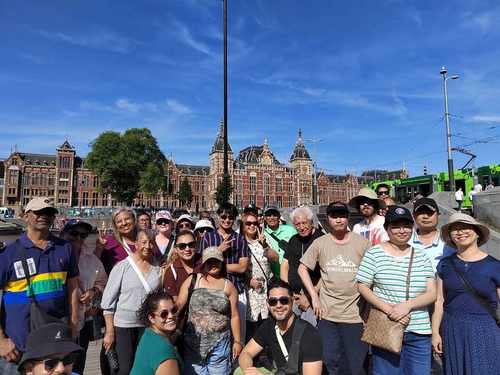 Groupe posant devant des bâtiments européens historiques.