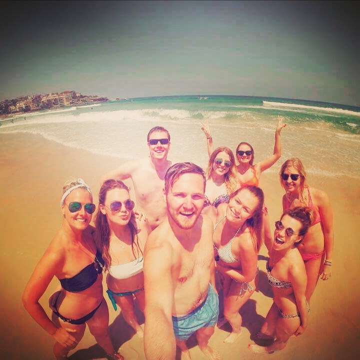 Group of friends posing together on a beach.