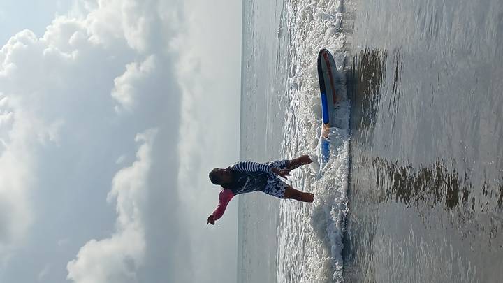 Person surfing on small waves near the shore.