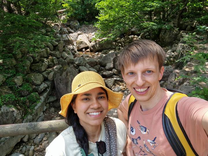 Couple posing in front of a rocky stream.