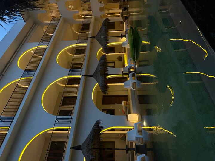 Lit swimming pool at a resort with arches.