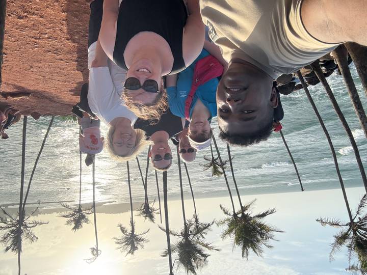 Groupe de personnes posant ensemble avec une vue côtière.