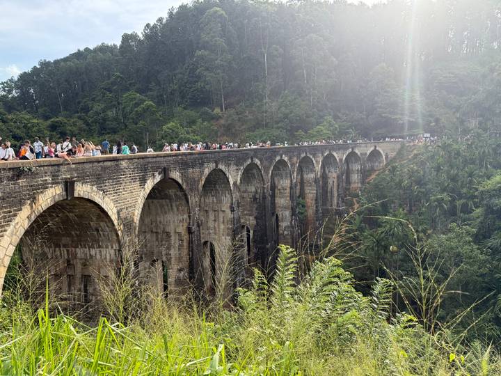 Vue panoramique du pont aux neuf arches avec des personnes marchant dessus.