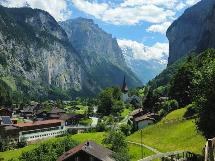 Magnifique village alpin avec une église et une vallée verdoyante.