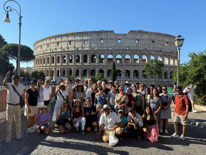 Groupe de touristes posant devant le Colisée.