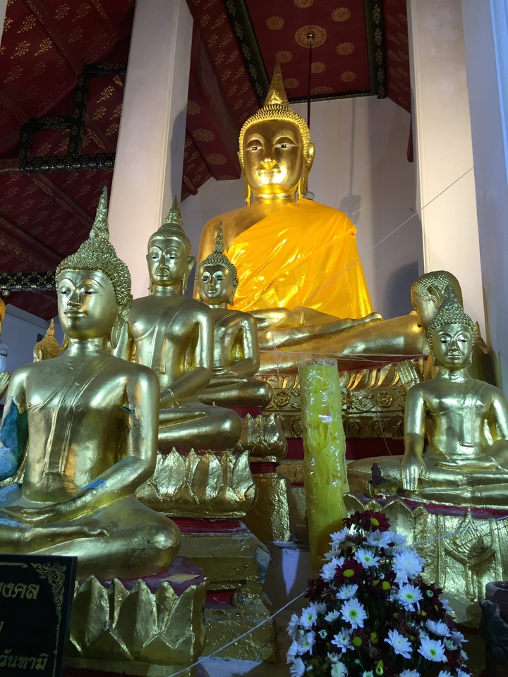 Several golden Buddha statues inside a temple.