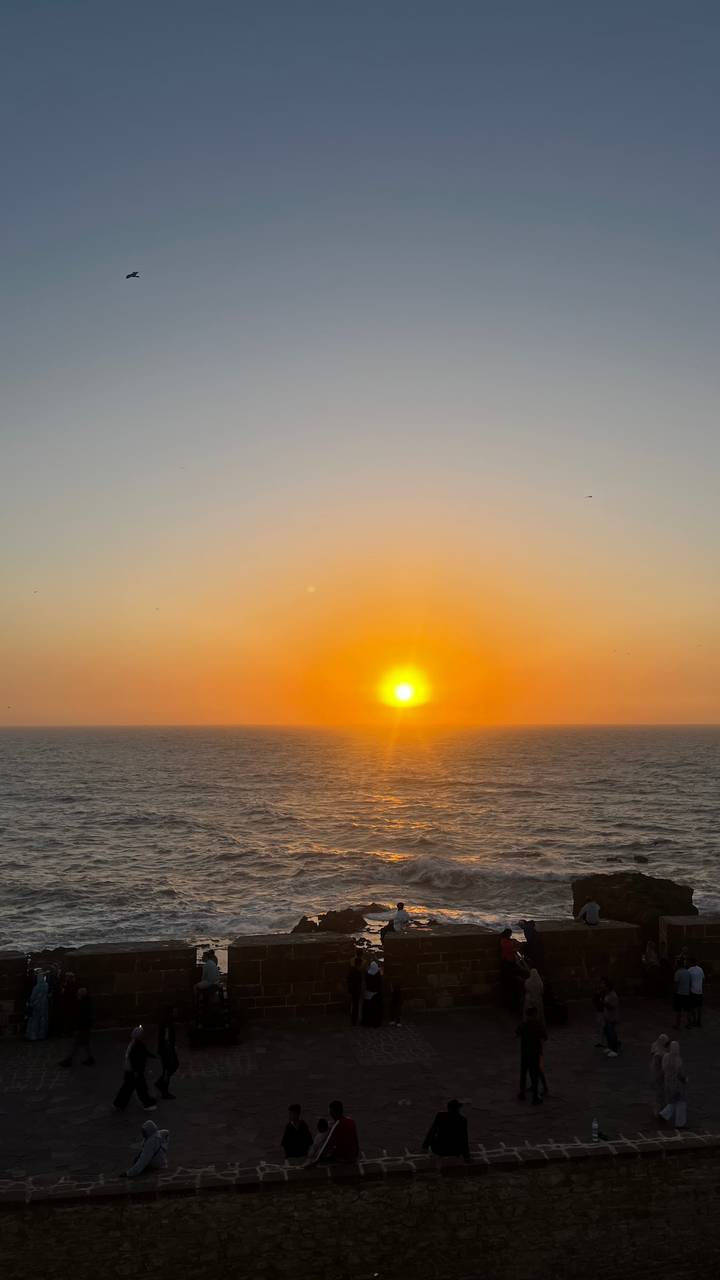 Sunset over the ocean with a clear view of the sun setting.