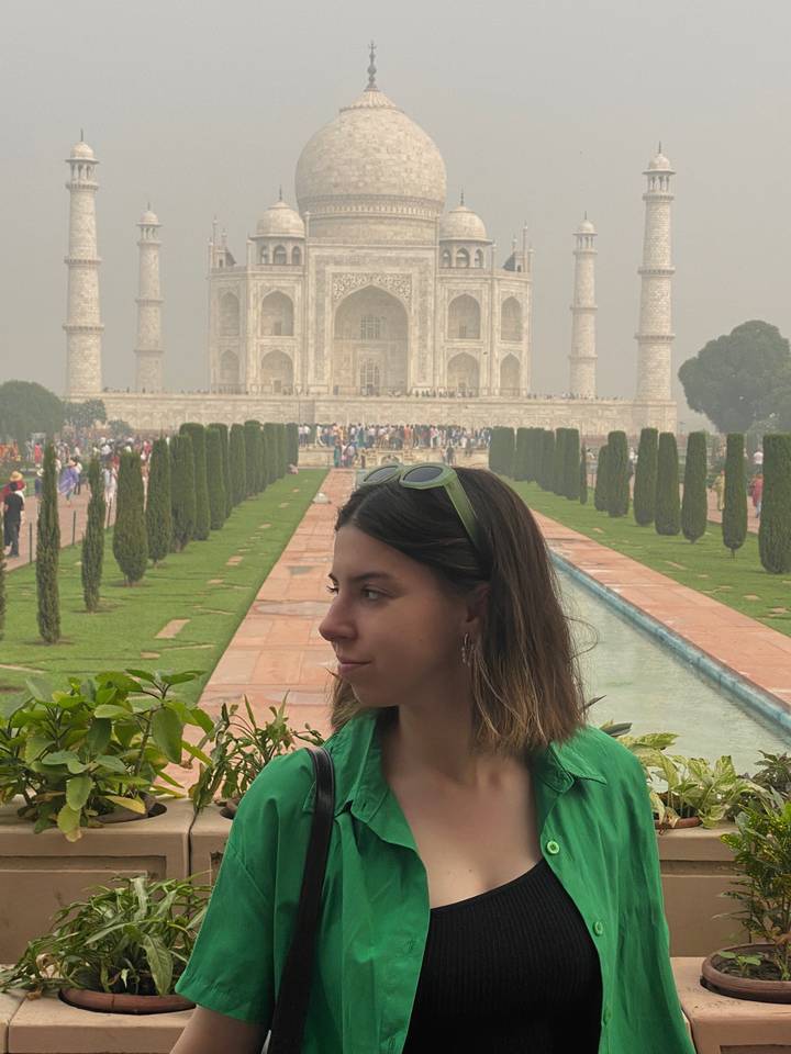 Woman posing in front of the Taj Mahal.