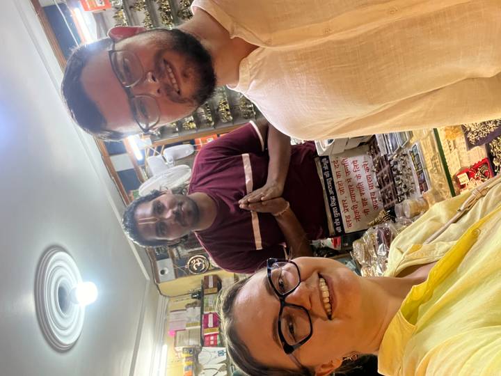 Three people posing inside a shop with local goods.