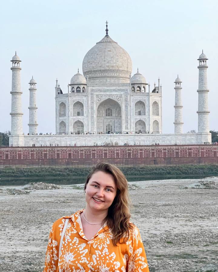 Woman posing in front of the Taj Mahal.