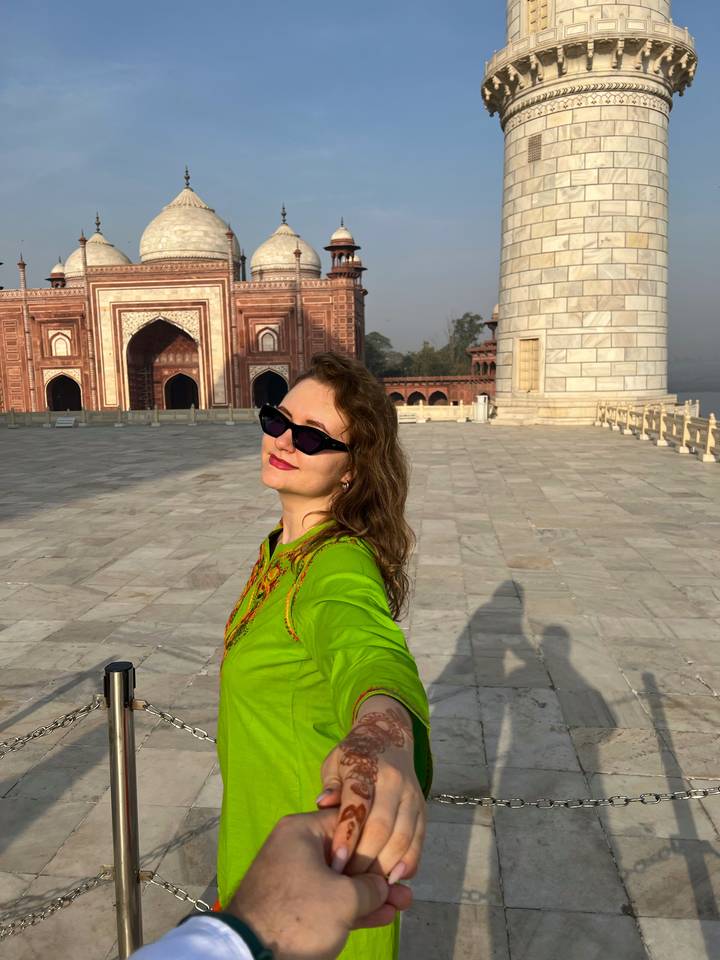 Woman posing on a marble terrace of a historic site.