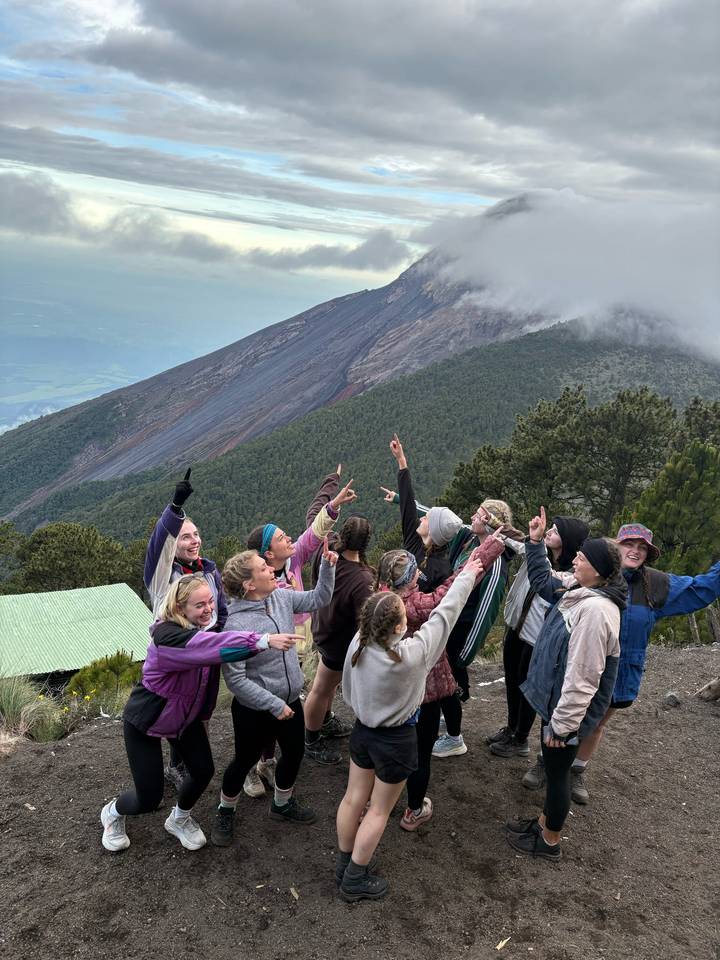 Groupe enthousiaste pointant vers le sommet du volcan Acatenango.