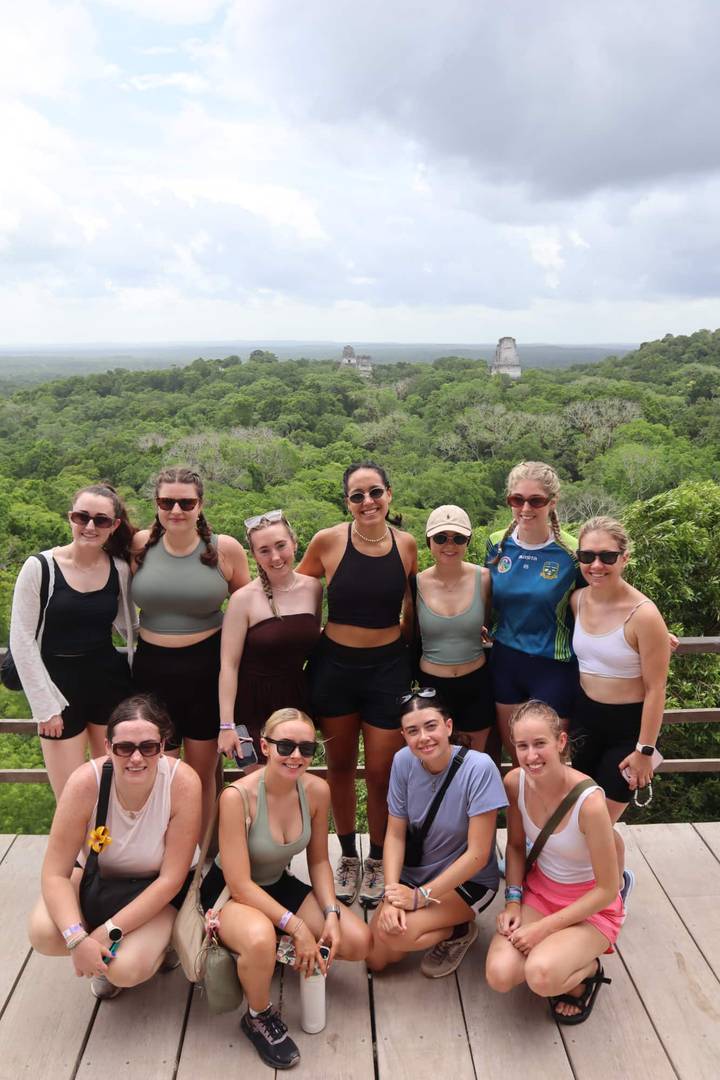 Photo de groupe avec en arrière-plan une jungle luxuriante et des temples visibles.