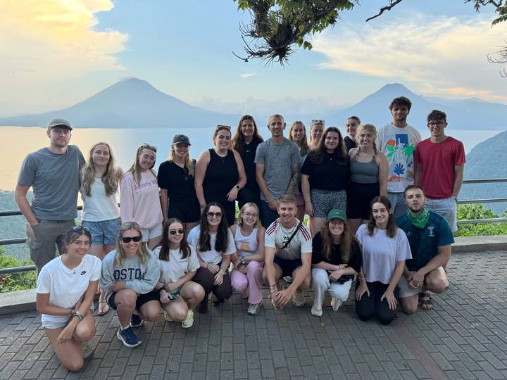 Groupe de jeunes adultes posant devant des volcans.