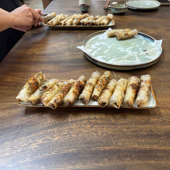 Een bord met krokante loempia's netjes gerangschikt.