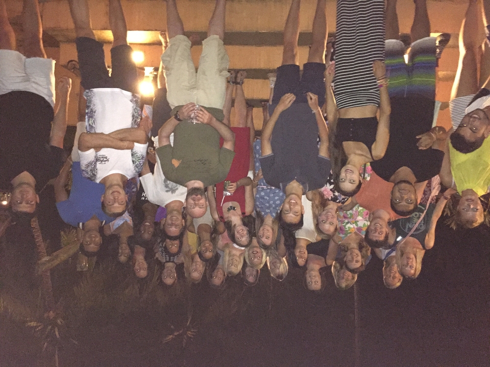 Large group of people posing together at night.
