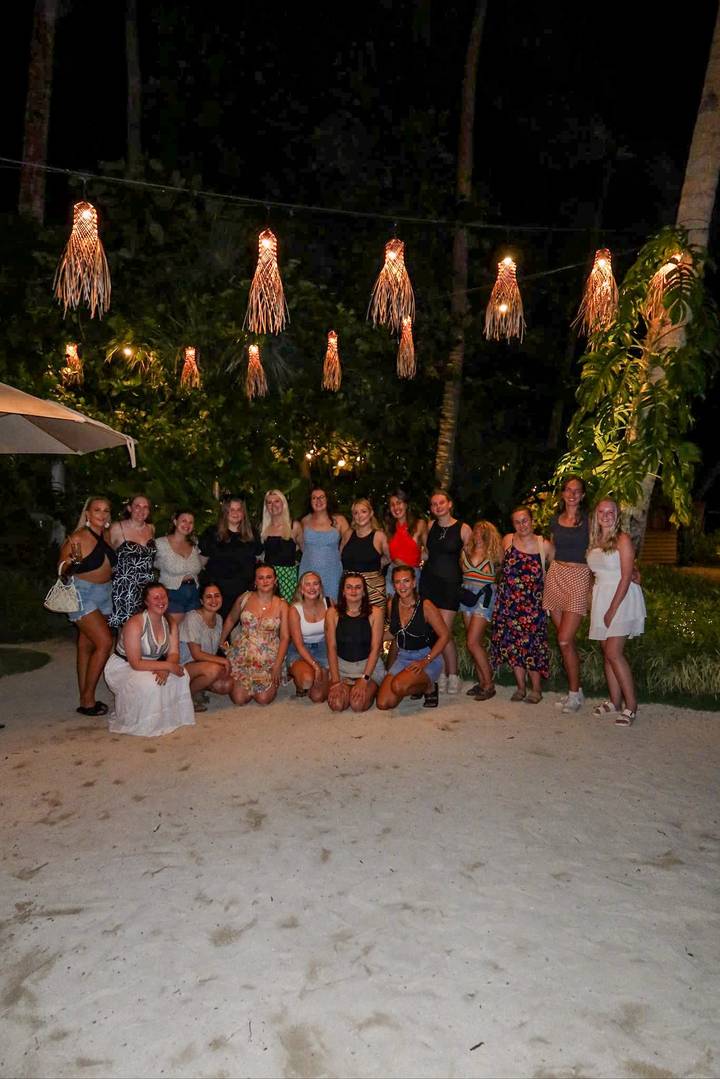 Photo de groupe de personnes posant la nuit dans un jardin.