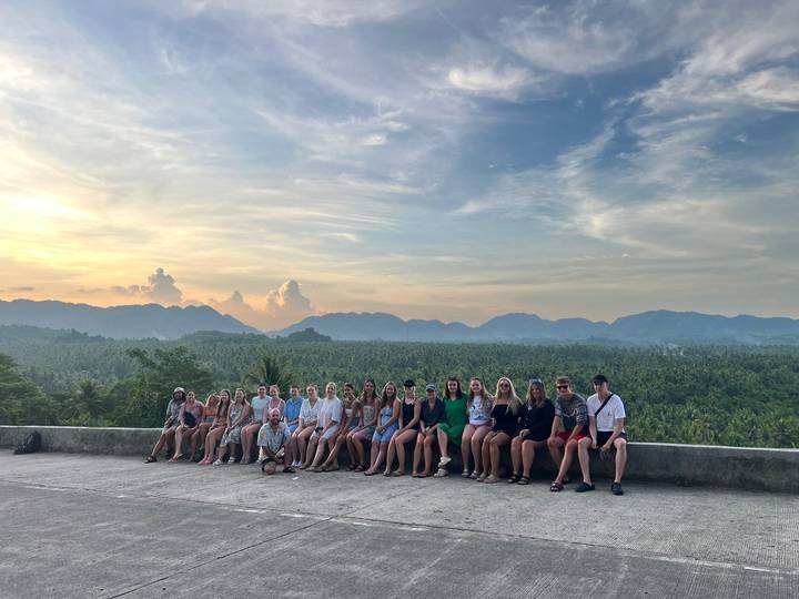 Grand groupe posant sur un point de vue avec vue sur la montagne