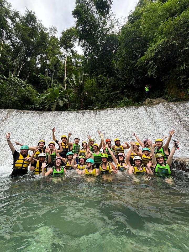 Groupe de personnes devant une cascade portant des casques